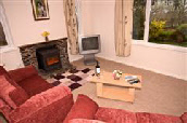 The comfortable lounge with wood burner and lovely views over your private garden.